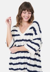 Strickpullover mit V-Ausschnitt, mit horizontalen Streifen in Marineblau und Creme. Lockerer Schnitt mit Dreiviertelärmeln und strukturiertem Garn.