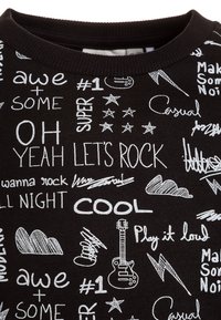 Czarna bluza z białymi graficznymi napisami i ilustracjami, w tym gitarą, gwiazdami i chmurami. Tekst zawiera frazy takie jak "ZACZNIJMY ROCKOWAĆ" i "FAJNIE".