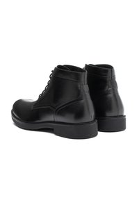 Botas de cuero negro hasta el tobillo con punteras redondas, textura suave, diseño con cordones y una sólida suela de goma negra. La vista trasera destaca los detalles de costura.