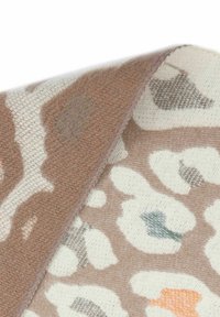 Leoprindruckstoff in Hellbeige, Braun und subtilen blauen Akzenten. Weiche Textur mit gefaltetem Rand und kontrastierendem Stich.