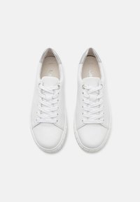 Hvite lær sneakers med rund tå, snøring, hvite snøringer og en sølvfarge på hælen. Glatt tekstur og minimalistisk stil.