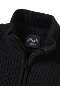 Schwarzer, gerippter Strickpullover mit Reißverschluss vorne. Mit hohem Kragen und einem Etikett mit der Aufschrift "Utopia MEDIUM" im Nacken.