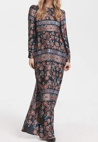 Robe longue noire à fleurs avec des manches longues, des motifs complexes dans des nuances de bleu et de rouge, et un corsage ajusté avec une jupe fluide.