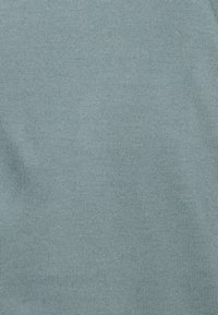 Ljusblått stickat tyg med en mjuk textur och subtila ränder. Enhetlig färg utan mönster eller synliga detaljer.