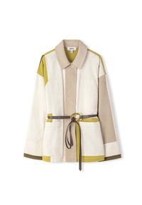 Veste bicolore en nuances de crème, beige et vert olive, avec une taille ceinturée et deux poches avant. Tissu texturé avec un design moderne.