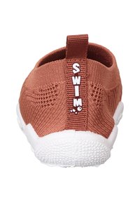 Wasserschuhe mit einem gestrickten Obermaterial in Terrakotta und einer weißen Gummisohle. Verfügt über eine Fersenlasche, die mit "SWIM" gekennzeichnet ist, für einfaches Anziehen. Strukturiertes Design.