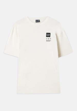 Kratke majice s kratkimi rokavi iz off-white bombaža, ki imajo pravokotni črn logotip in navodila za nego tiskana v črni barvi na prsih.