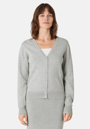 Gilet gris clair avec un col en V, des manches longues et une fermeture bouton. Sa texture douce et les détails en côte au niveau de l'ourlet complètent le design.
