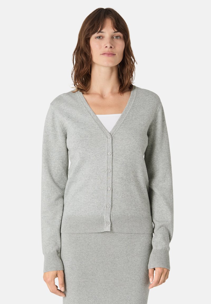 Světle šedý kardigan s výstřihem do V, dlouhými rukávy a zapínáním na knoflíky. Měkká textura a žebrovaný lem doplňují design.