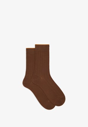 Calze a coste marroni con una finitura testurizzata, caratterizzate da un accento arancione sulla parte superiore per un tocco di dettaglio in più. Design di lunghezza standard per calzini a tubo.