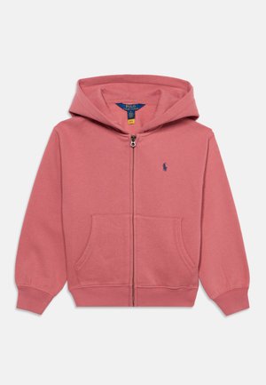 Sweat à capuche rose zippé intégralement avec poche avant, poignets côtelés et capuche, avec un petit logo brodé bleu marine sur la poitrine gauche.