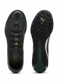 Svarta sportskor med en texturerad ovandel, gröna accenter och en mönstrad sula. Har snörning och en distinkt Puma-logga.