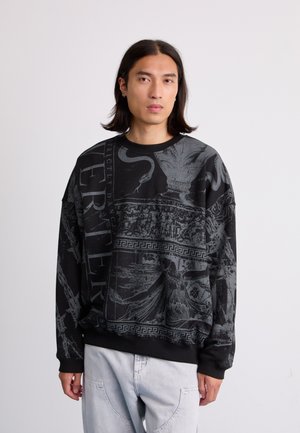 Black sweatshirt with a bold, textured gray graphic design, featuring ancient motifs and lettering. Ribbed cuffs and collar.
