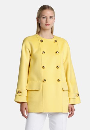 Yellow wool blend coat with a double-breasted design, gold-tone buttons, and flap pockets. Features a relaxed fit and wide sleeves.