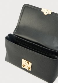 Black leather handbag with a structured shape, gold hardware closure, and interior compartments. Textured exterior with smooth lining.