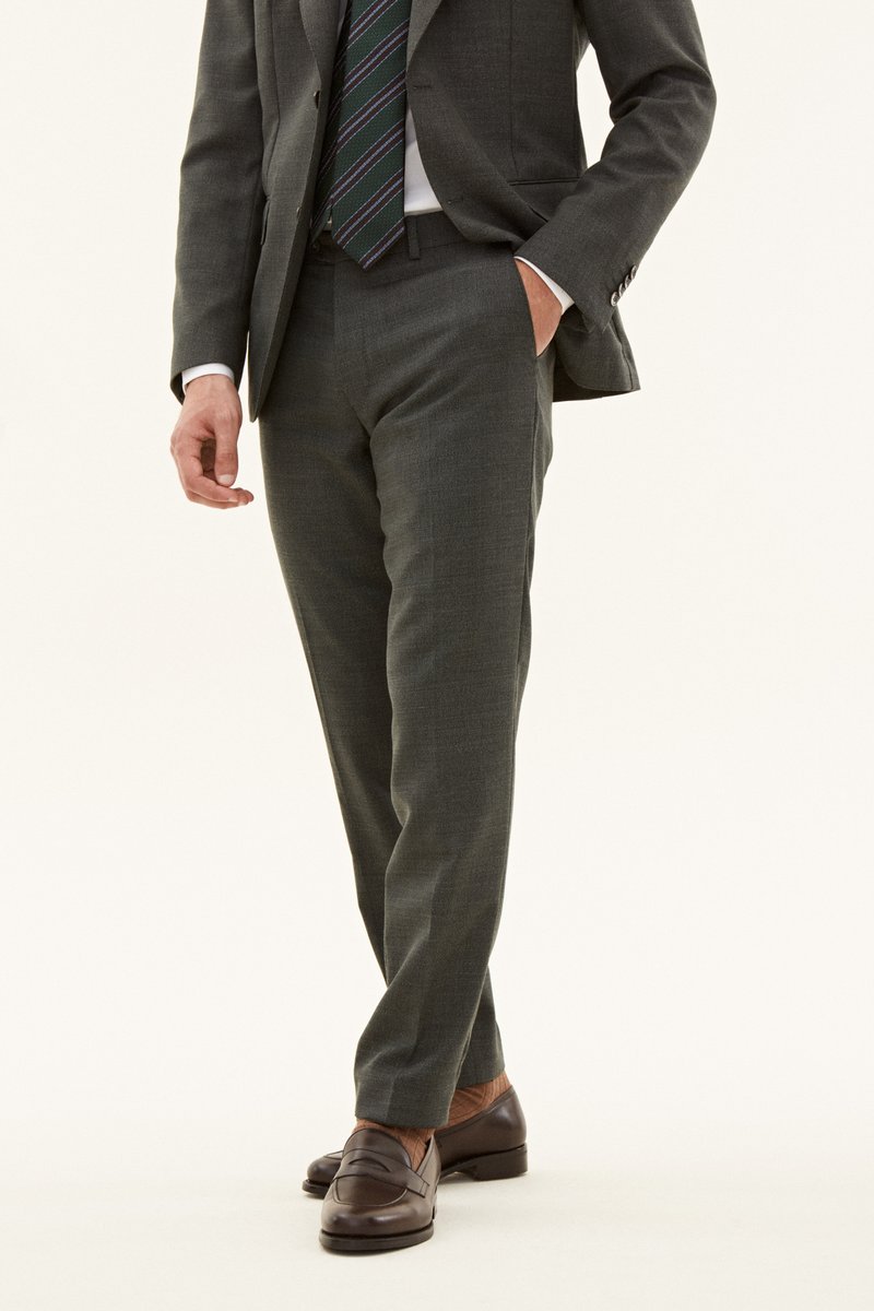 Graue maßgeschneiderte Hose aus strukturiertem Stoff, gerade Passform, mit Seitentaschen, kombiniert mit dunkelbraunen Lederloafers.