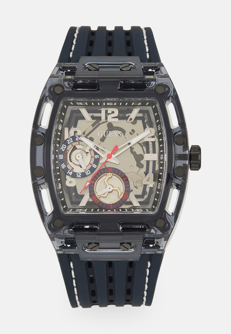 Przezroczysty prostokątny zegarek z ciemnoniebieskim gumowym paskiem. Posiada szary cyferblat, czarne akcenty i czerwone detale na sub-tarczach.