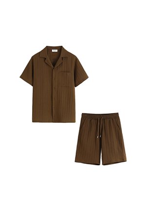 Chemise à manches courtes côtelée marron avec un poche poitrine, associée à un short à taille élastique avec cordon de serrage assorti.