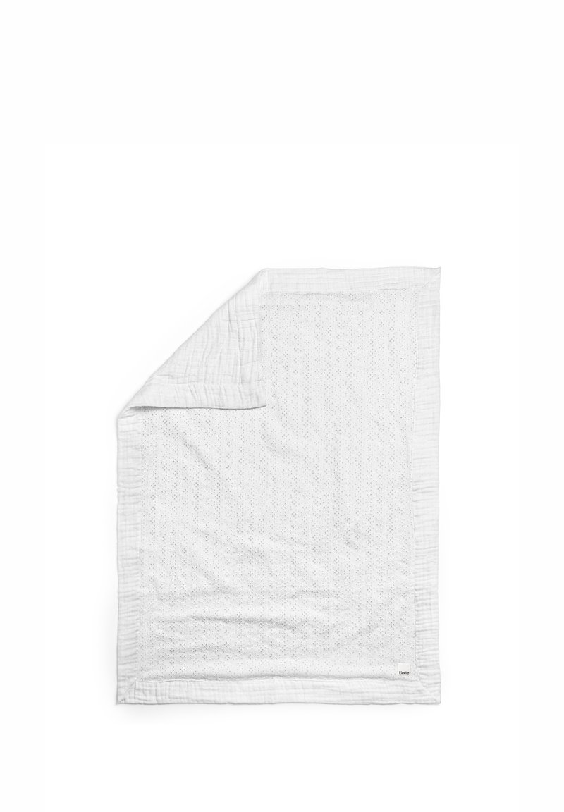 Vit quilt med en strukturerad yta som har ett subtilt mönster av små hål. Kantad med en sömnadsdetalj. Mjuk, lättvikts tyg.