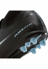 Scarpetta da calcio nera con tomaia strutturata, tacchetti blu sulla suola e design elegante con dettagli riflettenti. Marchio Air Zoom visibile.