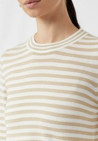 Gestreifter Strickpullover mit abwechselnd beige und weißen Streifen, rundem geripptem Ausschnitt und glatter Textur.
