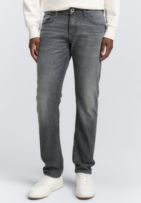 Jean en denim gris avec une coupe droite, design à cinq poches, légères décolorations et accents brodés. Associés à des baskets blanches.
