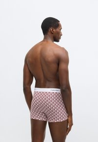 Μπόξερ της Calvin Klein με γεωμετρικό σχέδιο σε μπορντό και λευκό, με λευκή ελαστική μέση με λογότυπο.