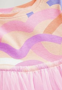 Texturerat tyg i pastellfärger, med vågiga mönster i rosa, lila och orange, samt en rynkad rosa tyllkant vid fållen.