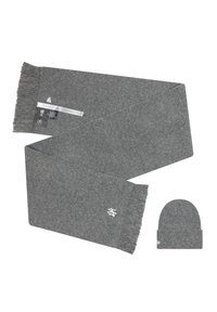 Bufanda de punto gris con flecos en los bordes y logotipo bordado; acompañada de un gorro gris a juego. La tela parece suave y cálida.