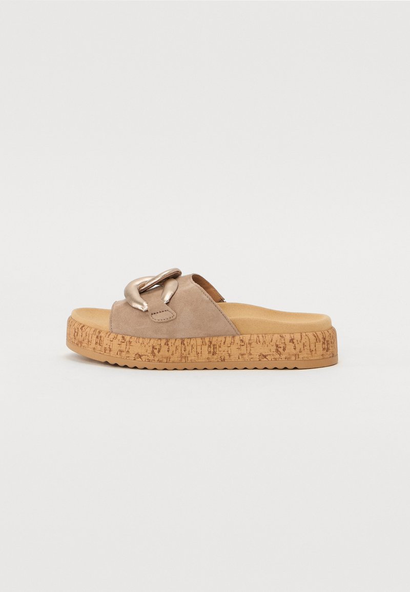 Beige suede slide sandals with a metallic chain accent, cork sole, and textured platform. Flat with an open back and rounded toe.