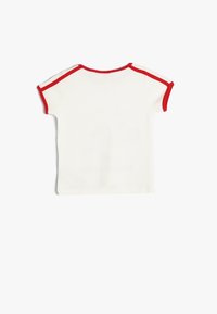 Hvid kortærmet t-shirt med rød ribbet kant langs halsudskæringen og ærmekanterne. Blød bomuldsstruktur, klassisk pasform med rund hals.