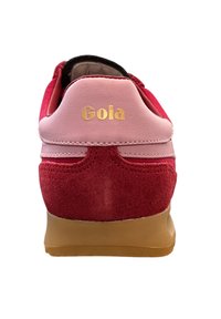 Red and pink sneaker with suede and textured leather, featuring a rounded heel and tan rubber sole. Gold "Gola" branding on the back.