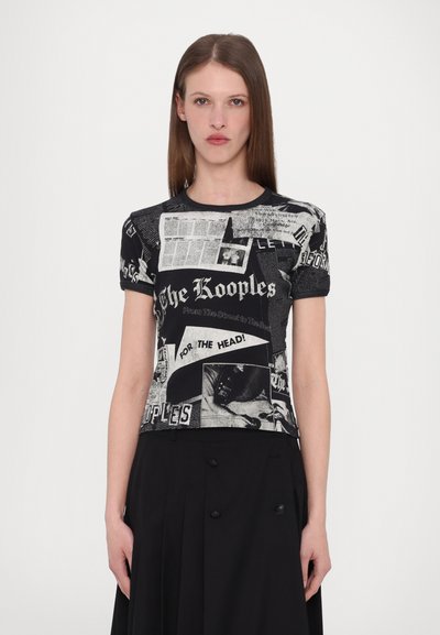Black and white graphic t-shirt featuring newspaper-style print with text and images; short sleeves, round neckline, fitted design.
