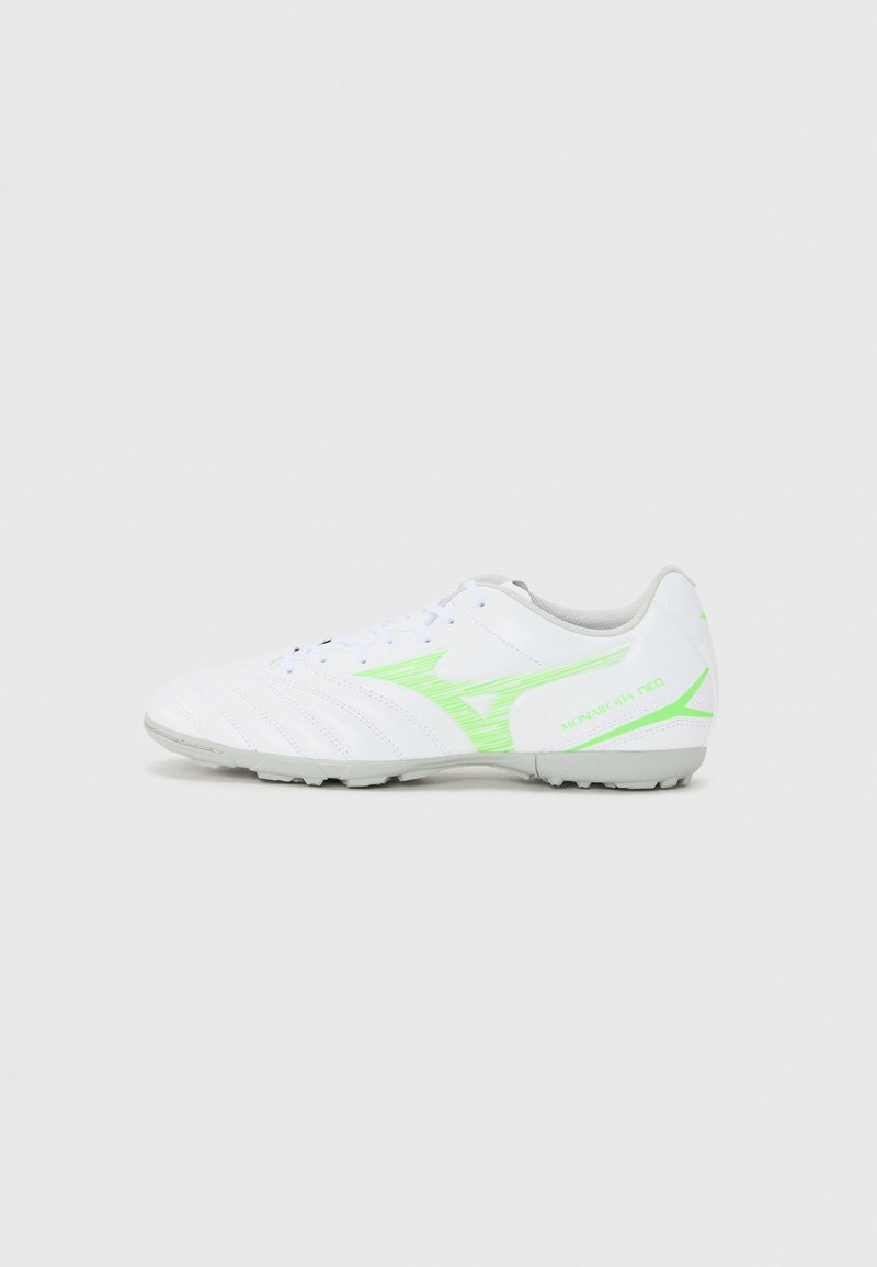 Zapatos de fútbol blancos con un diseño texturizado, acentos verdes y detalles grises. Presentan una punta redonda y una suela con tapones moldeados para mayor tracción.
