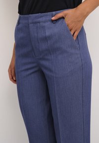 Pantaloni blu su misura realizzati in tessuto testurizzato, dotati di tasche frontali e design a gamba dritta. La vita presenta passanti per cintura per un tocco di stile in più.