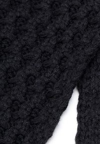 Tessuto nero lavorato a maglia con un motivo strutturato e in rilievo. Materiale soffice simile alla lana, di peso elevato e finitura irregolare e accogliente.