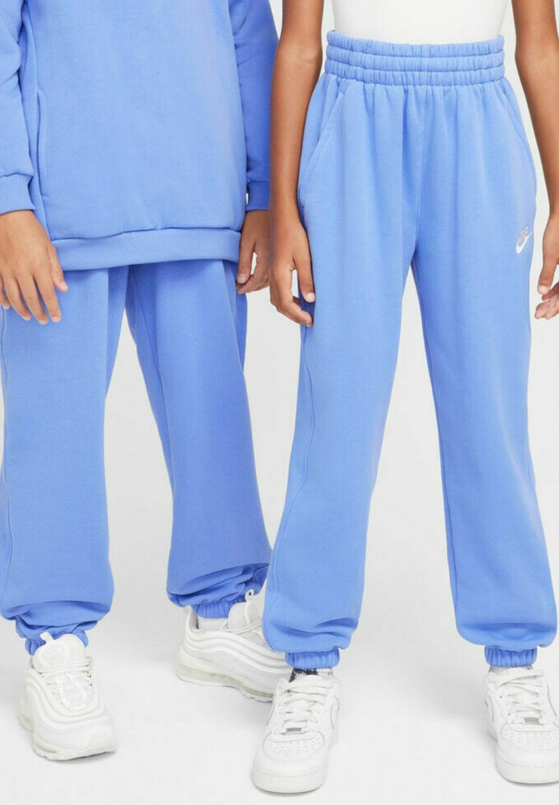 Pantalones de chándal azul claro con cinturilla y puños acanalados, que cuentan con bolsillos laterales y un pequeño logotipo blanco en una pierna.