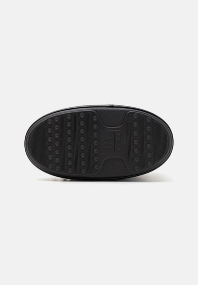 Black rubber shoe sole featuring a textured surface with raised circular patterns and grooves for grip. Straight-edged shape, no visible logos.
