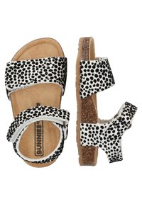 Zwart-witte sandalen met stippen, voorzien van verstelbare banden, een kurken zool en een zachte binnenvoering, met een vlakke basis en gestructureerde oppervlakken.