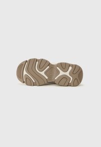 Suola di scarpa con un design ondulato, gomma testurizzata in tonalità di marrone e crema, con treads pronunciati e un logo al centro.