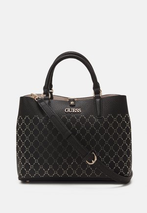 Czarna torebka Guess z górnymi uchwytami, regulowanym paskiem na ramię, dekoracyjnym wzorem wycięć oraz złotym logo i okuciami.