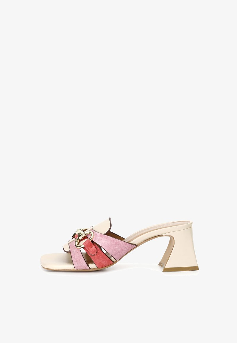 Chunky heeled sandals in pink suede with cream accents, featuring a gold circular buckle and an open-toe design. Low, square heel.