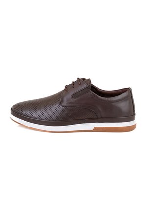 Chaussures en cuir marron avec un design perforé, une semelle intermédiaire blanche et une semelle extérieure en caoutchouc. Système de laçage structuré et texture lisse.
