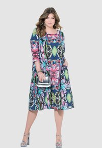 Vestido multicolorido de corte suelto con patrones florales y geométricos; mangas hasta la rodilla; escote redondo; la tela tiene una textura suave.