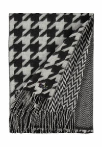 Kootud must ja hall tekk, millel on houndstooth muster, franjeäärtega ja väike brändi silt alumises nurgas.