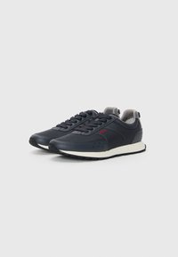 Navy blue sneakers with a smooth leather upper, gray accents, and a white midsole. Features lace-up design and textured rubber outsole.