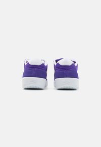 Baskets en daim violet avec des accents blancs, dotées d'un col rembourré, d'une semelle lisse et d'un logo de talon de marque pour plus de détails.