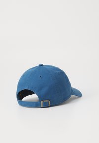 Blue cotton baseball cap with a curved visor, adjustable strap, and a metal buckle at the back. Features stitching and ventilation holes.