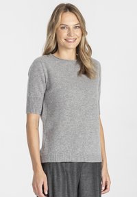 Szary sweter z krótkim rękawem, okrągłym dekoltem i ściągaczami na mankietach. Miękka faktura, dopasowany krój oraz rozcięcia po bokach u dołu zapewniające swobodę ruchów.