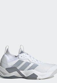 Scarpa sportiva bianca e grigia con tre strisce grigie, lacci, collo alto alla caviglia e testi ""Torsion System"" e ""Lightstrike Pro"" sulla suola.